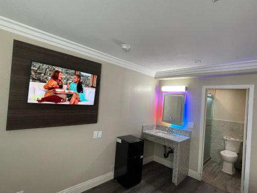 a bathroom with a flat screen tv on the wall at Diamond Inn in North Hills