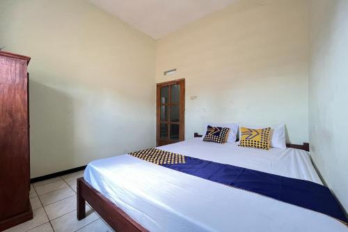 a bedroom with a bed with two pillows on it at Hotel O Kost Berkah Near Kebun Teh Wonosari in Lawang