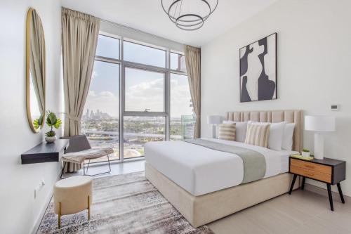 a white bedroom with a large bed and a window at Frank Porter - Park Gate Residences 1 in Dubai