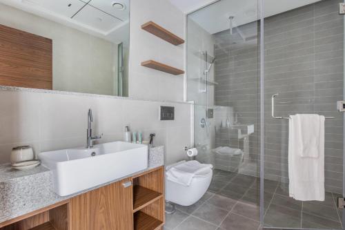 a bathroom with a sink and a toilet and a shower at Frank Porter - Park Gate Residences 1 in Dubai