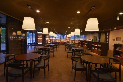 a dining room with tables and chairs and lights at Hotel Binario Saga Arashiyama in Kyoto