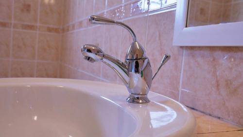 a bathroom sink with a chrome faucet on it at L'Idolivier in La Plaine des Palmistes