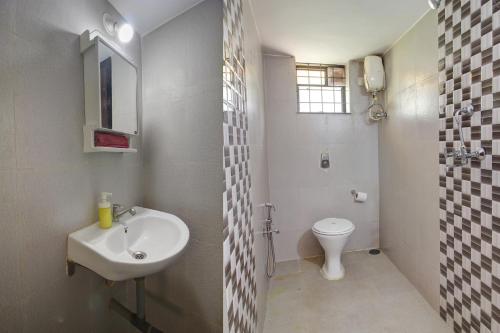 a bathroom with a sink and a toilet at Genesis Abode - Cosy 2 BHK Bungalow in Assagao in Mapusa