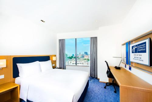a hotel room with a bed and a desk and a television at Holiday Inn Express Macau City Centre by IHG in Macau