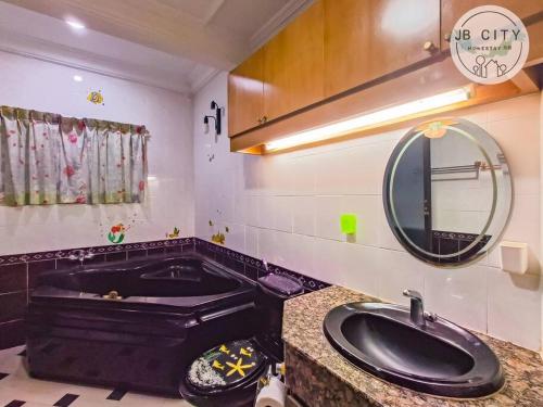 baño con bañera negra y lavamanos en Pelangi homestay by JBcity Home, en Johor Bahru