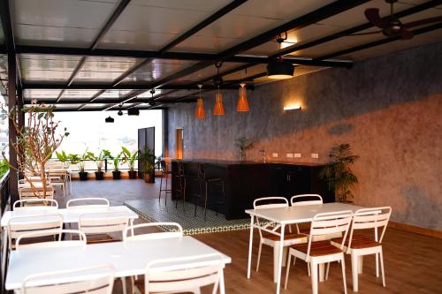 a restaurant with white tables and chairs and a bar at 32 Urban by Akoya Hotels in Hyderabad