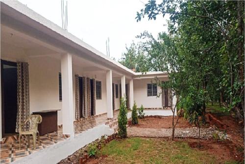 a white house with a chair in the yard at HOTEL LAKE SHIVALIK in Netarhāt