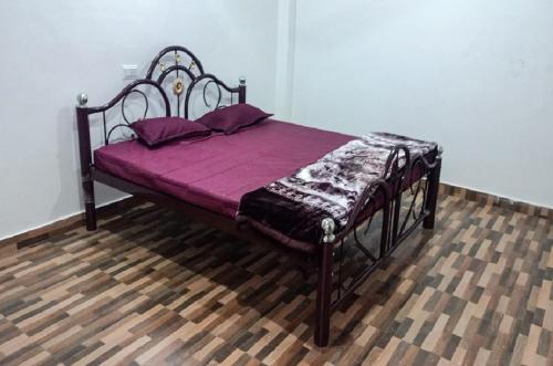 a bed in a room with purple sheets and pillows at HOTEL LAKE SHIVALIK in Netarhāt