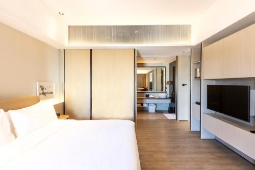 a bedroom with a bed and a flat screen tv at Artyzen Habitat Dongzhimen Beijing in Beijing