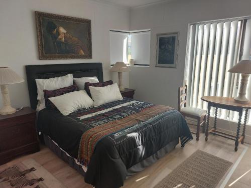 a bedroom with a bed and a painting on the wall at The Waves of Schulphoek in Hermanus
