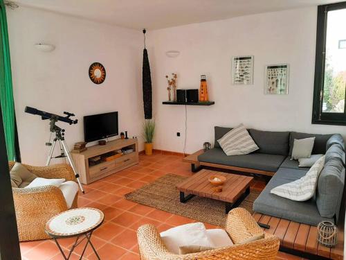 a living room with a couch and chairs and a television at ANANA Binisafua Preciosa casa al lado del mar in Binisafua