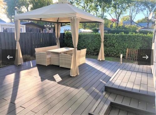 een tuinhuisje op een houten terras bij Vakantiehuis recreatiepark rhederlaagse meren lathum in Lathum