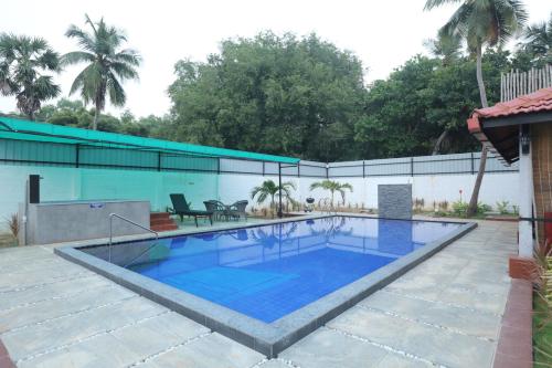 a large swimming pool with blue water at Athulya Resort -Leisure and Luxury cottages from EMBEHolidays in Kottaikadu
