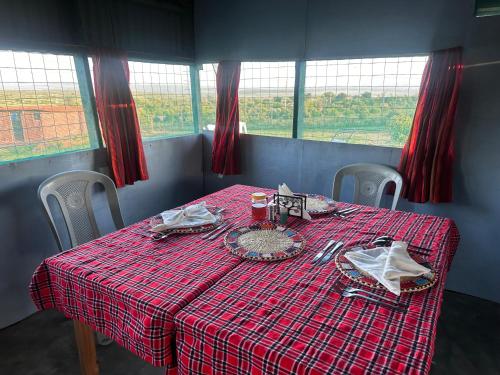 a table with a red checkered table cloth on it at Luluka Guest House in Sekenani