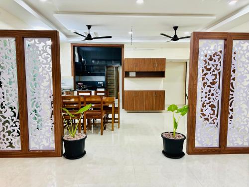 a kitchen and dining room with potted plants at TrueLife Majestic Suites - 3BHK Large Signature Apartments - PS4 Veg Restaurant - On the way to Balaji Temple - Modular Kitchen - Large Hall, Super fast WiFi, Smart TV, 250 Jio Channel - Easy access to all Temples - Parking - Top service with lots of Love in Tirupati