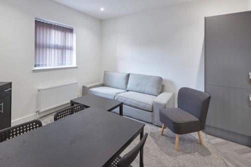 a living room with a couch and a table and chairs at Zetland House Apartment 2 Loftus in Loftus