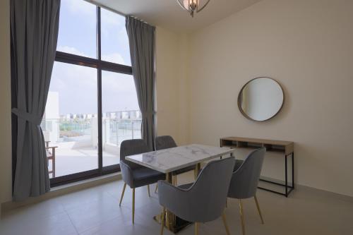 a dining room with a table and chairs and a mirror at Fabulous 4br villa with Balcony in Dubai