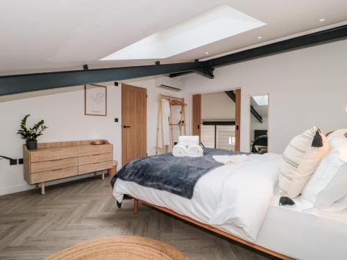a bedroom with a large bed and a mirror at Tilia Barn in Wincanton