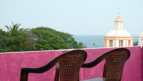 une paire de chaussures assise sur un banc rose dans l'établissement pondy Vibes 2bhk home Stay, à Pondichéry