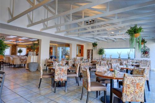 モッセル・ベイにあるProtea Hotel by Marriott Mossel Bayのレストラン内のダイニングルーム(テーブル、椅子付)