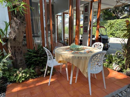 a table and chairs on the porch of a house at Warm White Hua Hin House in Hua Hin