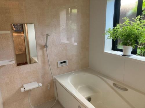 uma casa de banho com uma banheira e uma janela em Guest House Naze - Vacation STAY 14001 em Amami
