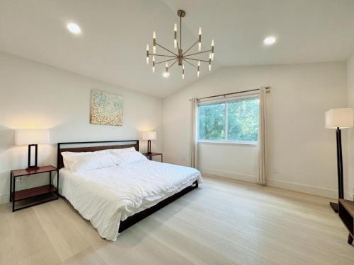 a bedroom with a large bed and a chandelier at Trendy Trenholm in Elk Grove