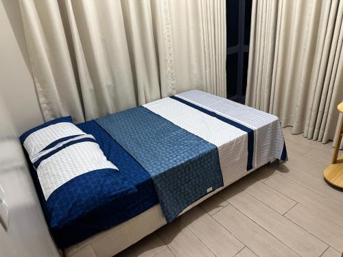 ein kleines Bett mit einer blau-weißen Decke darauf in der Unterkunft Family Home in The Florence McKinley Hill Taguig in Manila