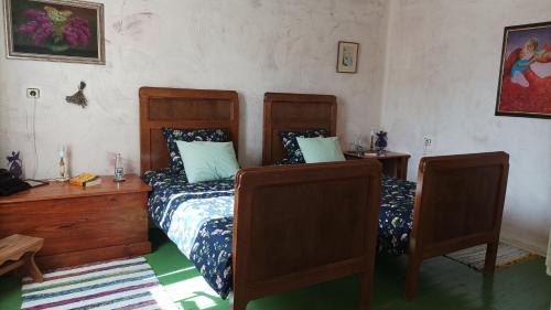 a bedroom with two beds and a table and a desk at Bilkarskata Kashta in Gorsko Slivovo