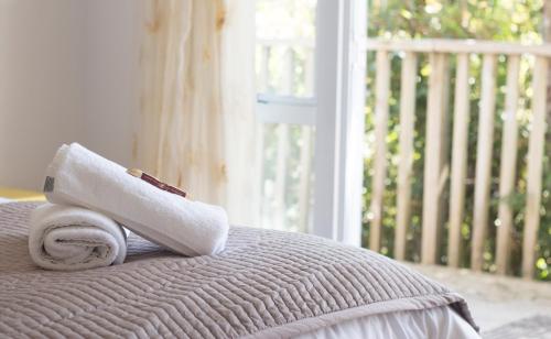 a stack of towels sitting on top of a bed at Aston Norwood Chalets in Upper Hutt
