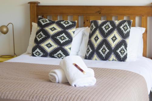 a bed with a towel animal on top of it at Aston Norwood Chalets in Upper Hutt