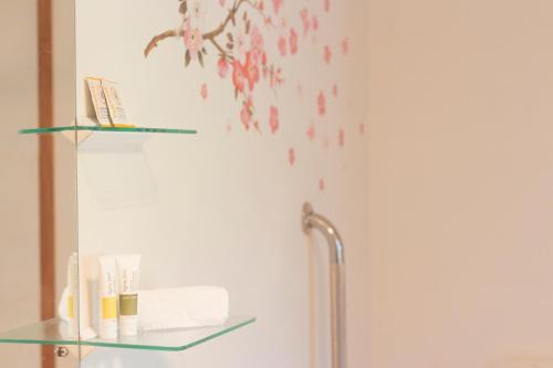 a bathroom with a glass shelf with toiletries at Aston Norwood Chalets in Upper Hutt