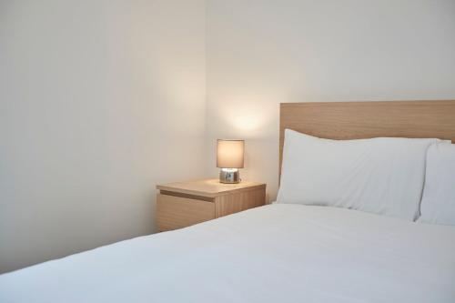a bedroom with a bed and a lamp on a night stand at Zetland House Apartment 3 Loftus in Loftus