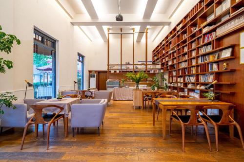 ein Restaurant mit Tischen und Stühlen in einer Bibliothek in der Unterkunft Wuyu Hotel - Chongqing Shapingba Three Gorges Plaza in Chongqing