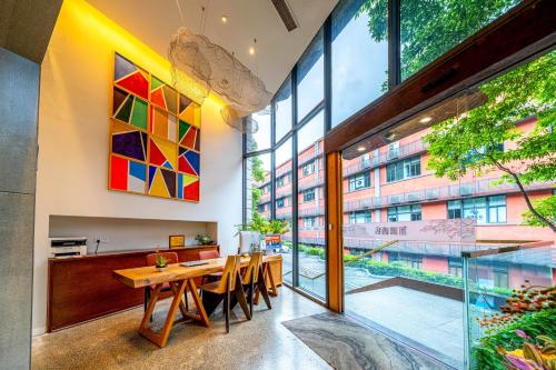 Wuyu Hotel - Chongqing Shapingba Three Gorges Plaza في تشونغتشينغ: غرفة طعام مع طاولة ونافذة كبيرة