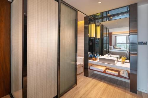 a bathroom with a sink and a mirror at Xunguang Hotel - Chongqing Liangjiang Happiness Plaza in Chongqing