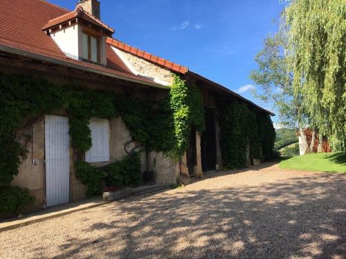 una casa con hiedra creciendo a su lado en Les Granges De Semur-en-brionnais With Heated Poo, en Semur-en-Brionnais