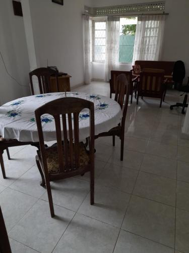 a table and chairs in a living room with a table and chairs at Palm Grove in Kalutara