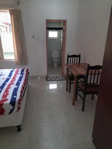 a bedroom with a bed and a table and a toilet at Palm Grove in Kalutara