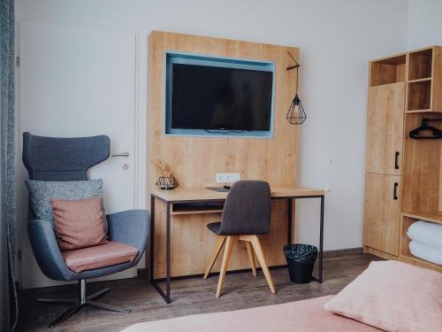 a bedroom with a desk and a chair and a television at Levy's Rooms & Breakfast in Salzburg
