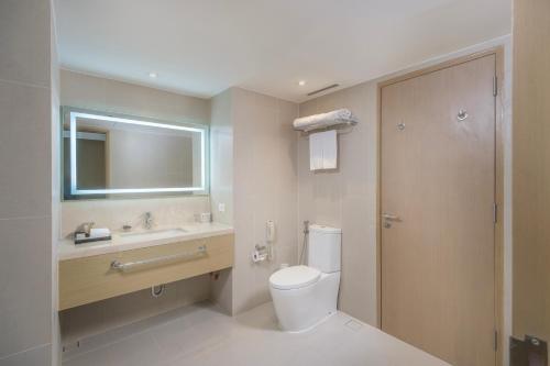 a bathroom with a toilet and a sink and a mirror at Seda Manila Bay in Manila