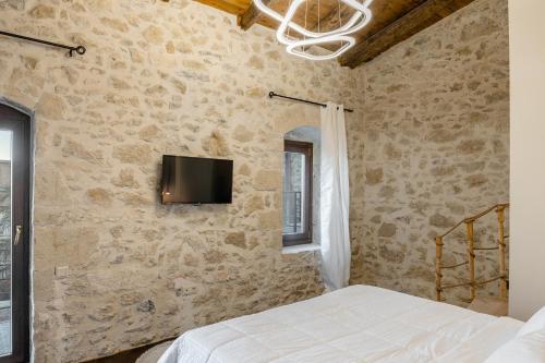 a bedroom with a bed and a tv on the wall at Athali villa in Krousón
