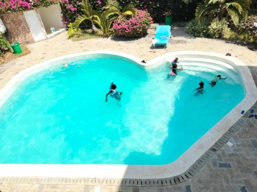a group of people swimming in a swimming pool at Makao Nafuu Aprtments Malindi in Malindi