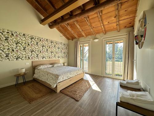 a bedroom with a bed and a large window at Canovetta Country House "Camelia" - nearby Cremona 