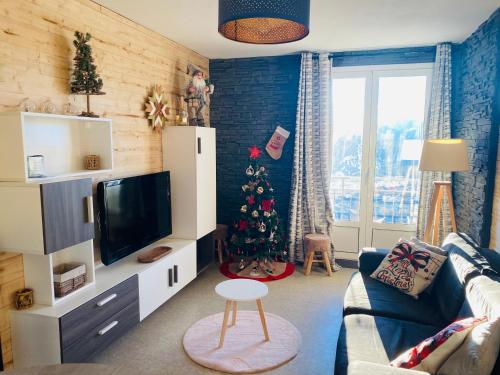 a living room with a christmas tree in the corner at Appartement, vue LAC Panoramique avec Terrasse, Parking, Aux Angles in Les Angles