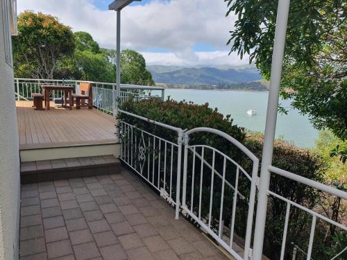 a balcony of a house with a view of the water at Takamatua Holiday Home in Takamatua Bay