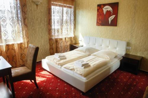 a bedroom with a large white bed and a chair at Hotel Krone in Friesenheim