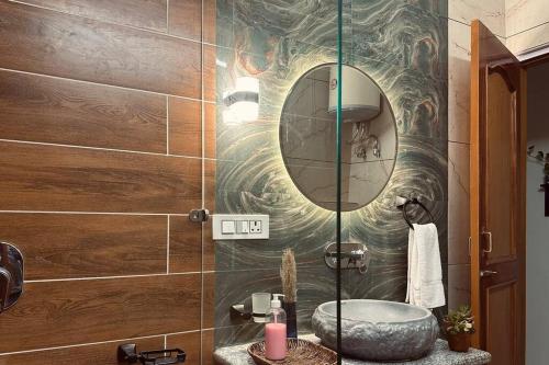 een badkamer met een wastafel en een spiegel bij Aikyam Niwas - 1BHK Apartment in Pālampur