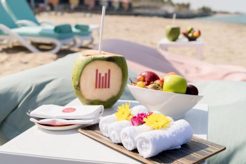 a table with a drink and a bowl of fruit at Grand Millennium Muscat in Muscat