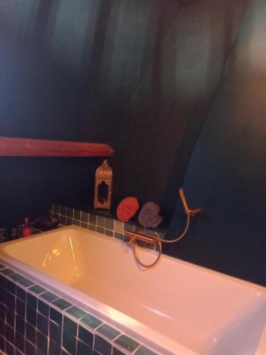 uma banheira na casa de banho com uma parede azul em Dilectus (Via Caput) em Lokeren